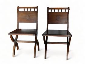 A pair of late Victorian oak hall chairs - the solid backs with vacant shield and solid seats, on