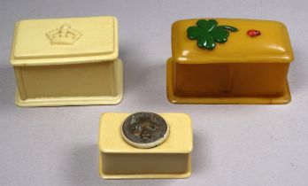 An early celluloid stamp box - decorated with a shamrock, width 7cm, together with another pair of