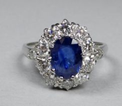 A platinum ring set a sapphire and diamonds - the central oval sapphire weighing 1.50ct