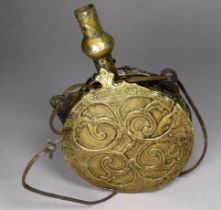 A late 19th/early 20th century Persian brass powder flask - circular with repousse decoration, of