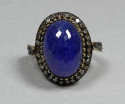 A large cabochon tanzanite and diamond set ring - with diamond shoulders, set in silver and gold,