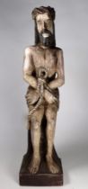 A carved polychrome figure of a bound man - height 50cm.