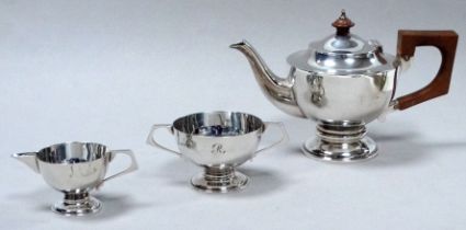 A silver three piece tea service - Brimingham 1907, engraved with the letter R, raised on circular