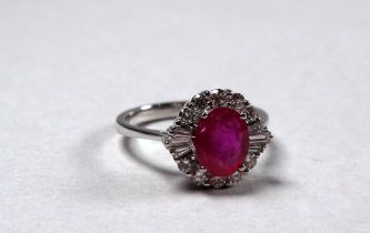 An 18ct white gold ruby and diamond set cluster ring - the central oval ruby weighing 1.59ct