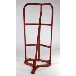 A Victorian wrought steel saddle rack - painted red incorporating a bridle hook below, length 51cm.