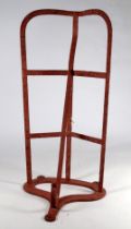 A Victorian wrought steel saddle rack - painted red incorporating a bridle hook below, length 51cm.