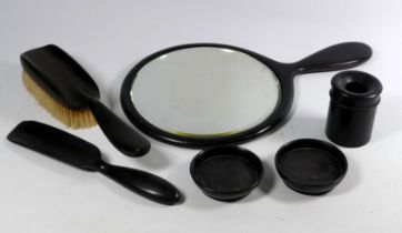 An ebony dressing table set - comprising hand mirror, two small dishes, shoe horn, brush and pin