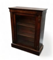 A Victorian walnut pier cabinet - the rectangular top above a glazed panel door enclosing two