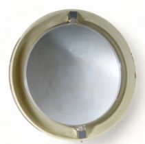 A 1970s back lit plastic circular salon mirror - on swivel supports within a white surround,