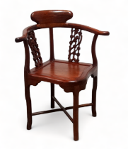 A 20th century Chinese hardwood corner chair - with yoke arms and pierced splats above a solid