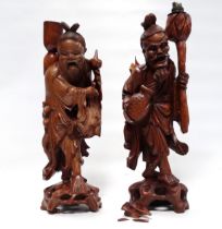 A pair of 20th century Chinese carved hardwood lamp bases - modelled as tradesmen, height 53cm.