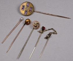 An amethyst set gilt stock pin - together with a pearl set pin and three others. (5)