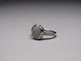 A 9ct white gold diamond ring - the oval cluster ring with diamond set shoulders, size N, weight 5.