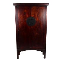 A mid 20th century Chinese hardwood cabinet - with a pair of panel doors incorporating a brass