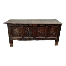 A 17th century and later carved oak coffer - the hinged plank top enclosing a void interior above