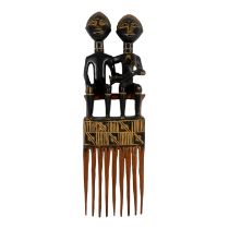 A large ceremonial comb - probably Asante, modelled with a male and female figure with a child,
