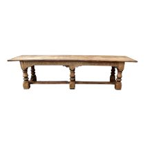 A 17th century and later oak refectory table - the cleated plank top above a base with carved