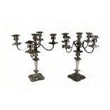 A pair of silver plated four branch candelabra - with foliate sconces and drip-pans, raised on a