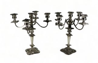 A pair of silver plated four branch candelabra - with foliate sconces and drip-pans, raised on a