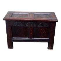 A diminutive 17th century oak coffer - the twin panel top above a guilloche carved frieze and a