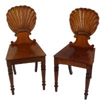 A pair of late Victorian mahogany hall chairs - with carved scallop shell backs and solid seats,