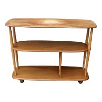 An Ercol elm and beech Baby Giraffe three tier trolley - model 361, incorporating a magazine divider