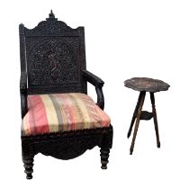 A late 19th century Burmese carved hardwood chair - the pierced back panel incorporating a figure