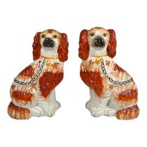 A pair of 19th century Staffordshire dogs - seated with russet decoration, height 24cm.