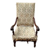 A 17th century style carved walnut and upholstered chair - the rectangular pad back above open arms,