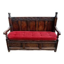 A 17th century and later reconstructed box seat settle - the panel back above solid hinged seat