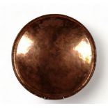 Hugh Wallace (British 1871-1943) a circular copper tray - with a rolled rim, bearing initials within