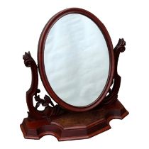 A Victorian mahogany toilet mirror - the oval plate flanked by pierced supports, on a plinth base