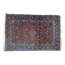 A Kirman style carpet - of floral garden design on a red ground within a blue border, 204 x 134cm