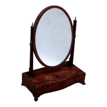 A 19th century mahogany toilet mirror - the oval plate between supports, raised on a serpentine base