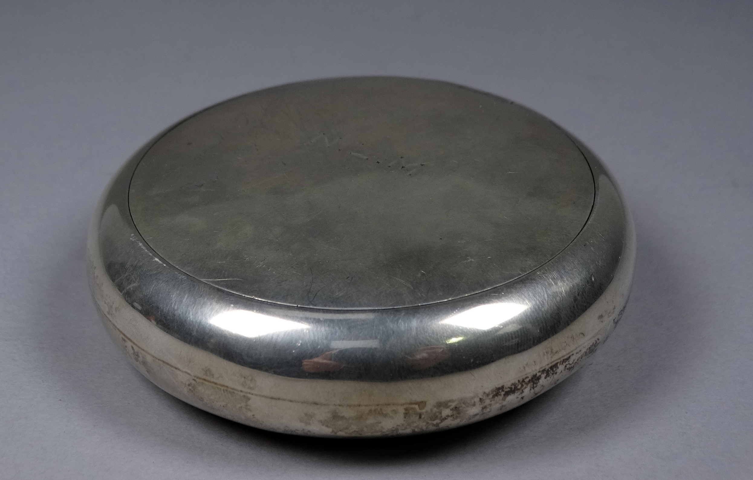 A silver tobacco box - London 1927, Goldsmiths & Silversmiths, of circular form with a gilded