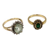 A 9ct gold emerald and diamond ring - the oval central stone within a band of diamonds, size M, 2.