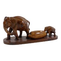 A carved hardwood group of an elephant and calf - probably Burmese, width 33cm.