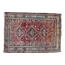 Persian rug - with an arrangement of three medallions on a red ground within a serrated multi-stripe