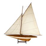 A 20th century pond yacht - Gaff rig, with white hull, red boot line and natural finish to hull,