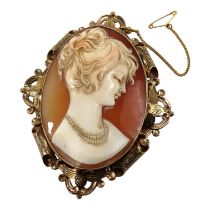 A cameo brooch - oval and carved with the image of a young woman, within a foliate and pierced