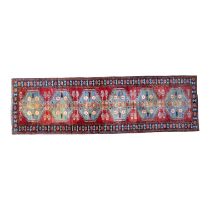 A Bokhara runner - with six light blue medallions on a red ground within a blue border, 286cm x