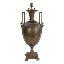 An early 20th century copper table lamp - of urn form with twin handles, raised on a square base,