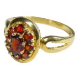 An 18ct gold and garnet ring - with an oval cluster setting, size Q, weight 4.2g.