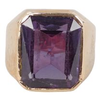 A gilt metal ring - with foreign purity marks and set with an emerald cut purple stone, size S,