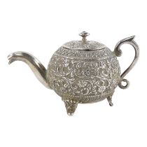 An early 20th century Anglo Indian white metal teapot - of bullet form and decorated with trailing