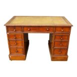 An early 20th century oak kneehole desk - the rectangular leather inset top above an arrangement