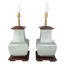 A pair of celadon glazed table lamps - of square baluster form with square stepped wooden caps and