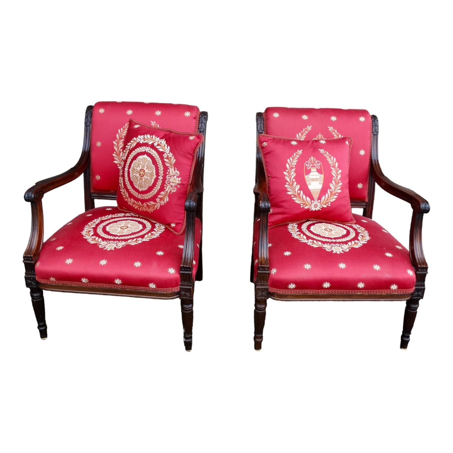 A pair of mahogany French Empire style chairs - with pad backs and open arms, on turned reeded legs.