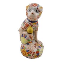 A 20th century Imari decorated monkey - seated holding a gilt pear of life, signed in characters