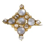 A yellow metal and moonstone set brooch - with an arrangement of circular cabochon cut stones.